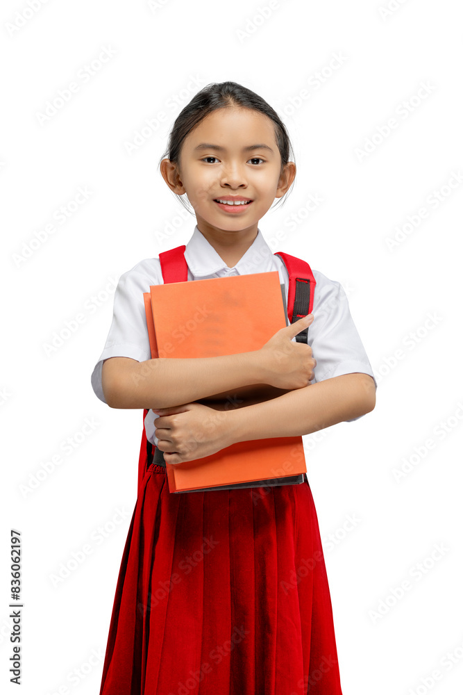 Portrait of an Asian elementary school student girl in uniform with a backpack standing while holding a book Portrait of an Asian elementary school student girl in uniform with a backpack standing while holding a book