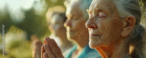 Serene elderly woman praying at sunset