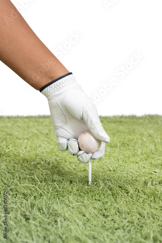 Golfer hand in a glove puts a golf ball on the tee