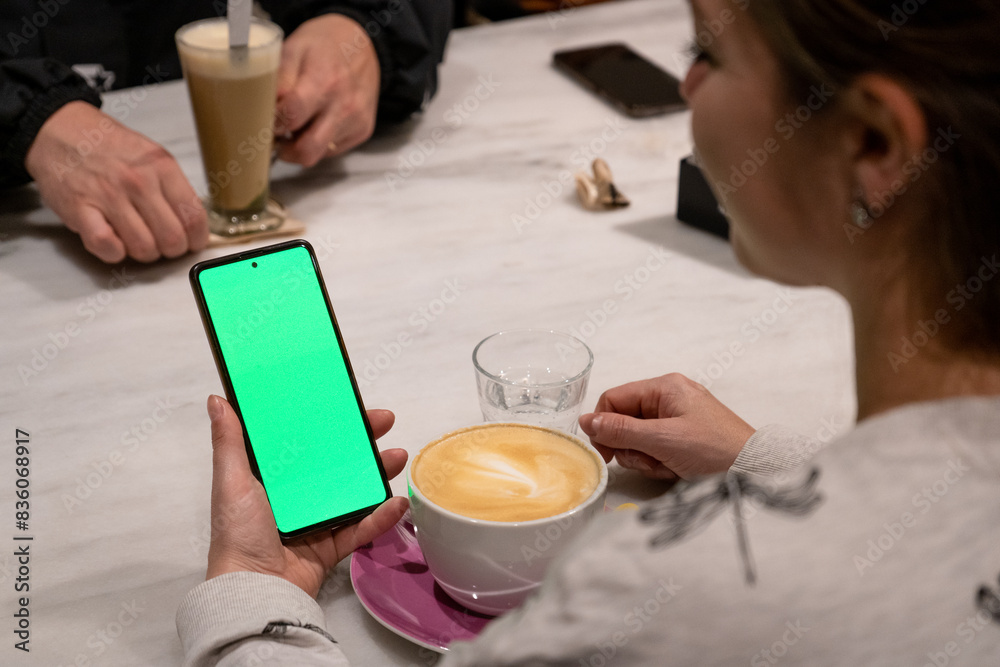 Mujer sosteniendo un teléfono móvil con la pantalla verde chroma key. Recurso gráfico para publicidades y anuncios Mujer sosteniendo un teléfono móvil con la pantalla verde chroma key. Recurso gráfico para publicidades y anuncios