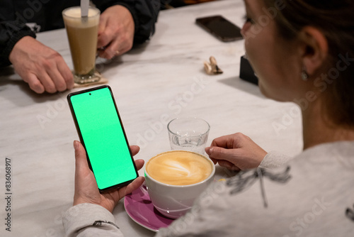 Cuadro en lienzo Mujer sosteniendo un teléfono móvil con la pantalla verde chroma key