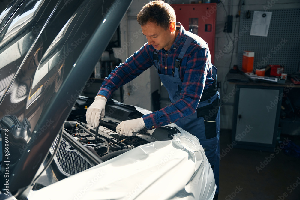 Young male repairing engine in vehicle service center Young male repairing engine in vehicle service center