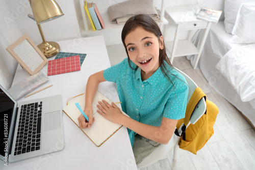 Little schoolgirl studying ...