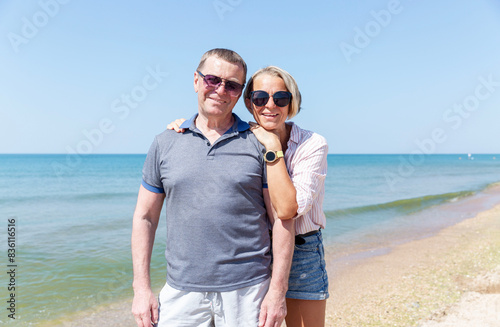 An adult daughter with an elderly dad at sea. Happy family smiling and hugging. Love and tenderness.