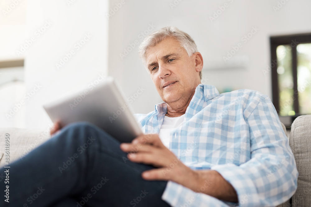 Relax, tablet and mature man on sofa for communication, networking or reading news article in living room. Online, technology and person for watching video, browsing internet or social media in home Relax, tablet and mature man on sofa for communication, networking or reading news article in living room. Online, technology and person for watching video, browsing internet or social media in home