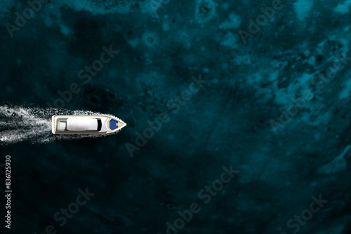 An expensive yacht sails on the ocean, top view
