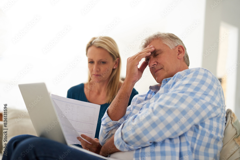 Couple, couch and document with laptop and stress, finances or taxes for debt in lounge. Paperwork, man and female person or online for mortgage, upset and budget for inflation or bankruptcy in home Couple, couch and document with laptop and stress, finances or taxes for debt in lounge. Paperwork, man and female person or online for mortgage, upset and budget for inflation or bankruptcy in home