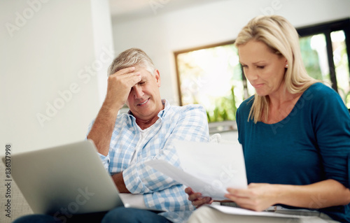 Mature, couple and home with laptop or documents, stressed man and woman planning for financial expenses. Bills, paperwork and online for tax review or budget, insurance contact and sofa in lounge © peopleimages.com