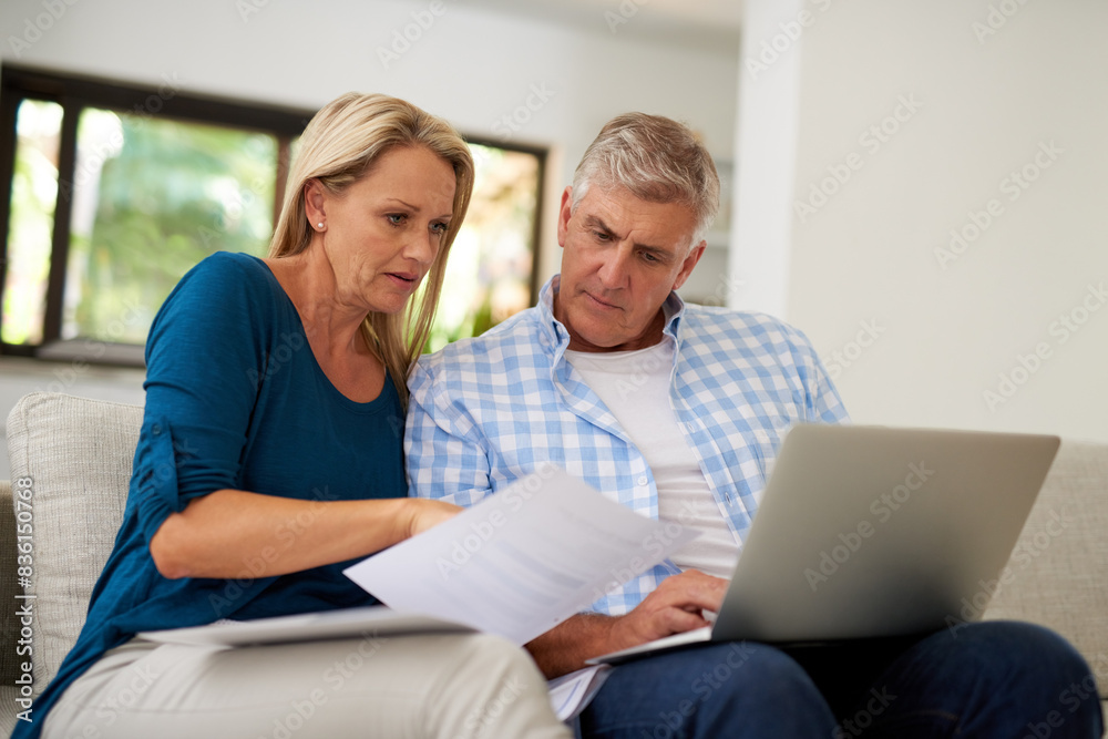 Couple, couch and document with laptop and read, finances or taxes for audit in living room. Paperwork, contract or online for mortgage insurance, investment or man with female person in home lounge Couple, couch and document with laptop and read, finances or taxes for audit in living room. Paperwork, contract or online for mortgage insurance, investment or man with female person in home lounge