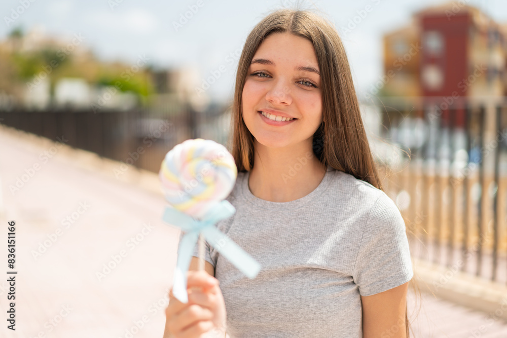 Teenager girl holding a lollipop with happy expression Teenager girl holding a lollipop with happy expression