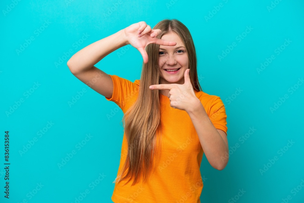 Young Russian woman isolated on blue background focusing face. Framing symbol