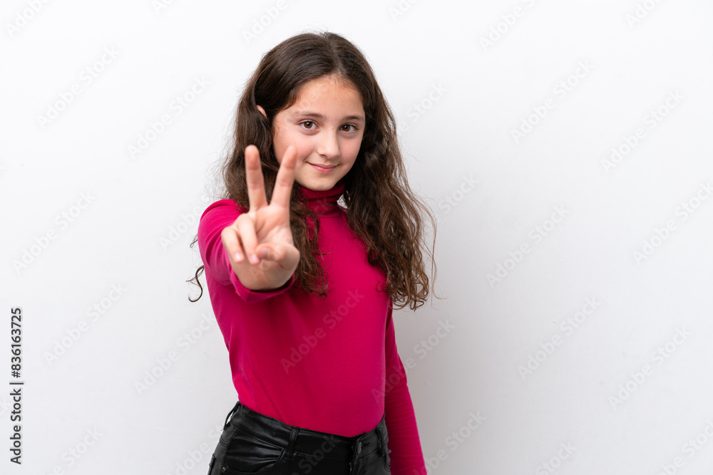 Little girl isolated on white background smiling and showing victory sign Little girl isolated on white background smiling and showing victory sign