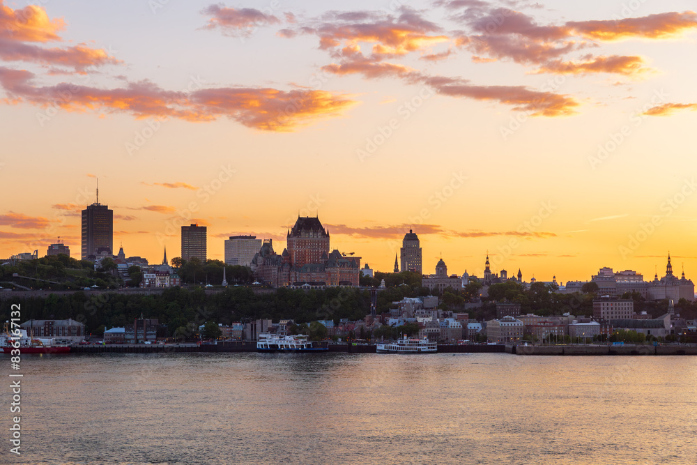 Obraz premium The Quebec City skyline seen at sunset from Lévis, with the St. Lawrence River in the foreground, Quebec, Canada