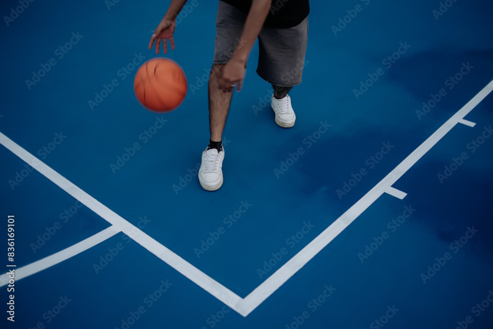 Fototapeta premium A single young man playing basketball