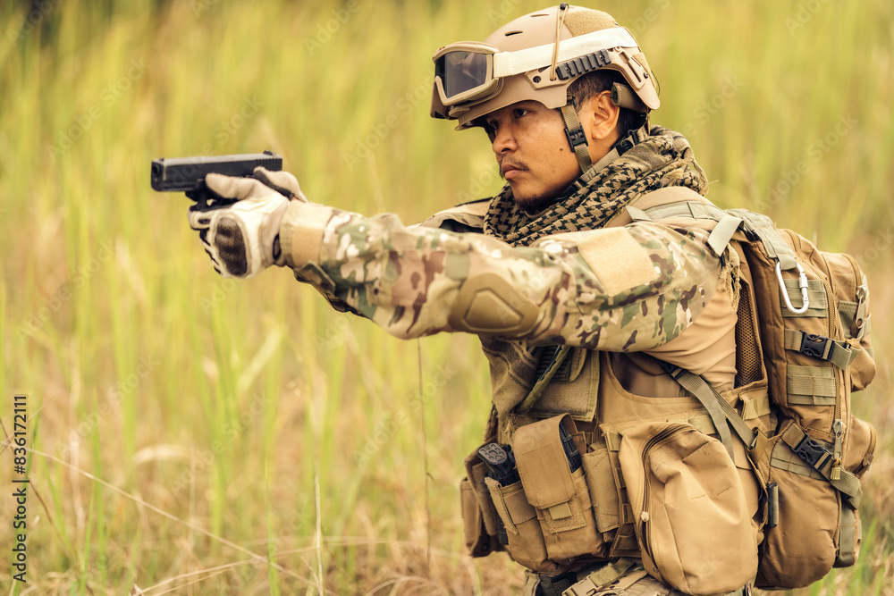 Fototapeta premium Brave soldiers tread carefully against danger and explosions. Their feelings are enhanced. Watch out for potential threats lurking in the dense undergrowth. Have your pistol ready to shoot.
