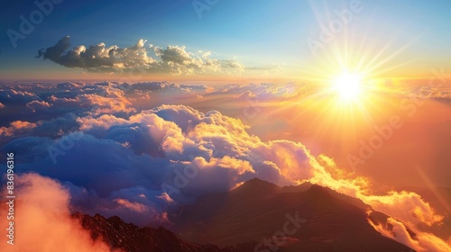 Mountain tops illuminated by sun surrounded by cloudless skies and soft clouds emitting peaceful and calm charm photo