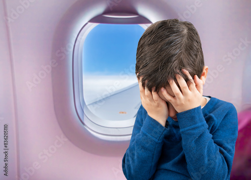 Close-up view of a child covering his face and crying.Headache in the airplane, kid passenger afraid and feeling bad during the flight in plane © cunaplus