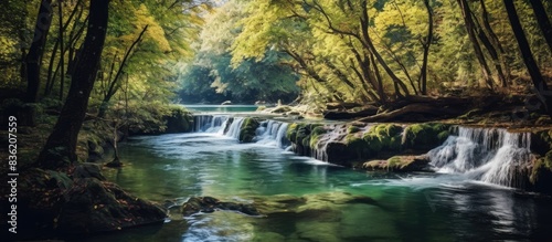 Nature s forest landscape showcases a picturesque waterfall cascade with a water stream  offering a beautiful scene with a copy space image.