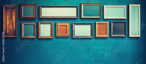Wooden frames hang on a weathered blue wall showcasing a vintage aesthetic with copy space image.
