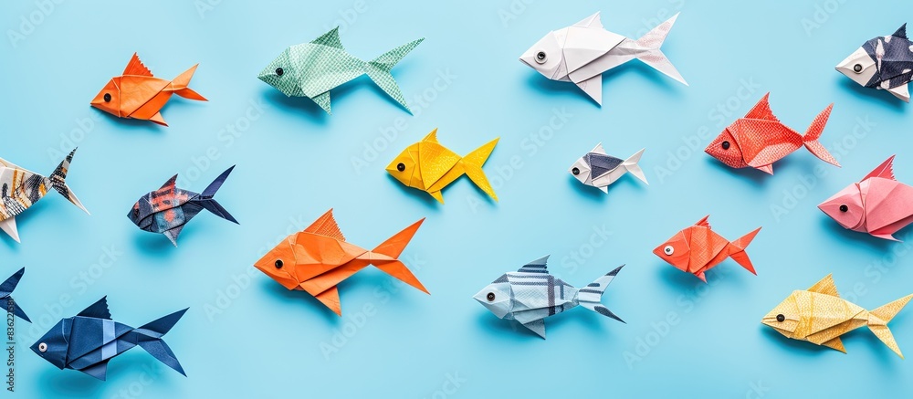 Fototapeta premium Learn to create an origami fish with paper sheets, scissors, and a brown wooden table in the background providing a copy space image opportunity.
