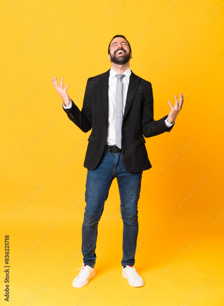 Full-length shot of business man over isolated yellow background smiling a lot Full-length shot of business man over isolated yellow background smiling a lot