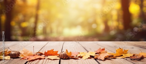 Autumn-themed background complements a wooden table with a clear surface for a vibrant copy space image. photo