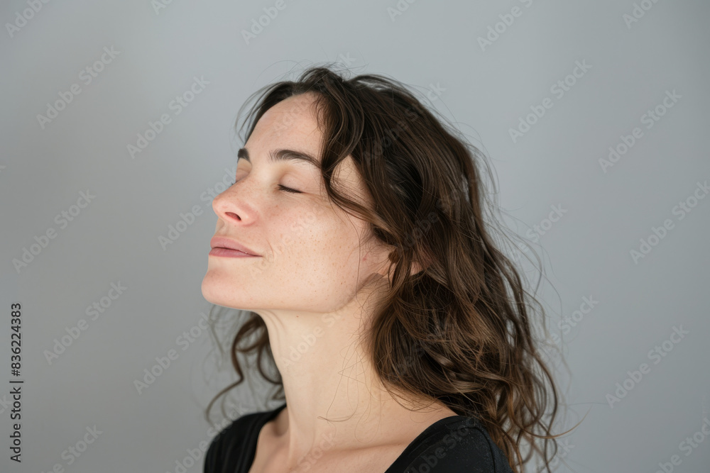 Fototapeta premium A close up of a woman's face with her eyes closed looking to a side