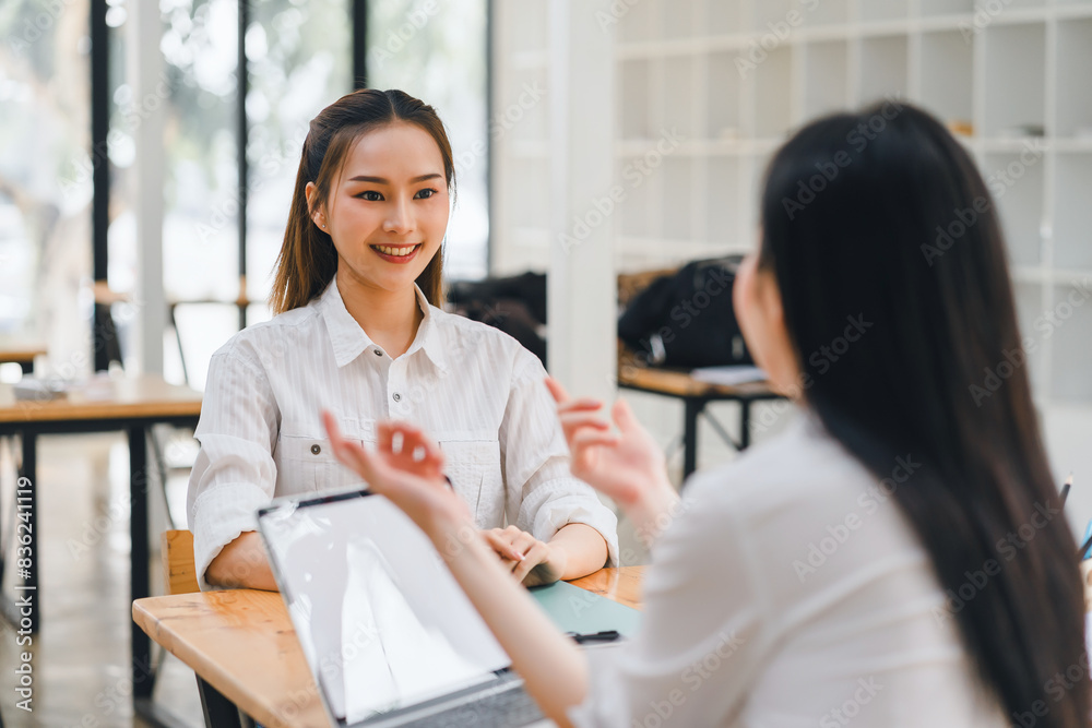 Smiling woman discussing work with colleague in modern office Smiling woman discussing work with colleague in modern office