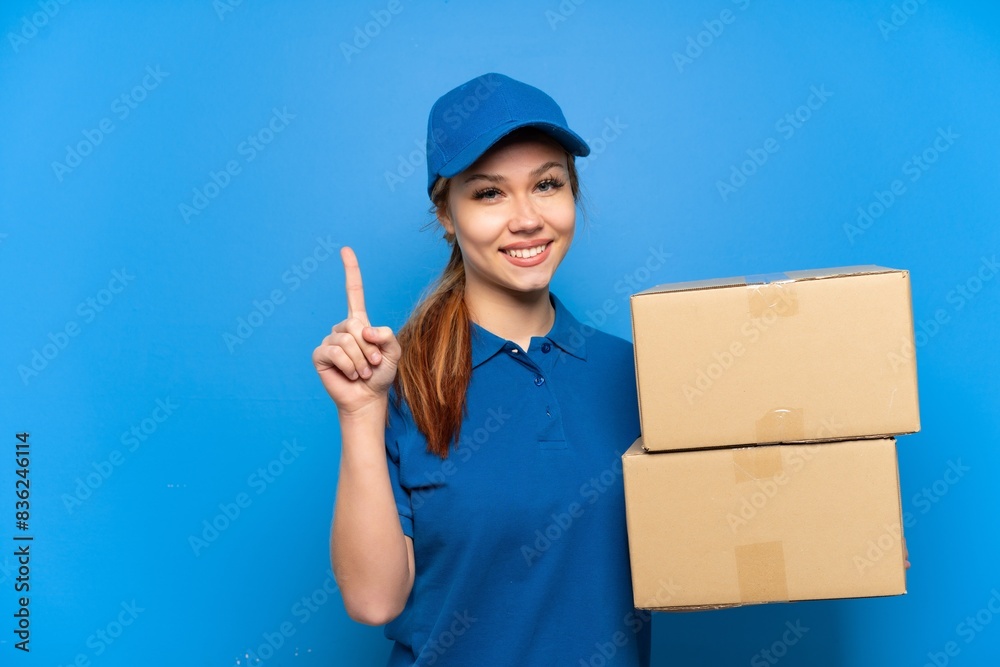 Delivery girl over isolated blue wall showing and lifting a finger in sign of the best Delivery girl over isolated blue wall showing and lifting a finger in sign of the best