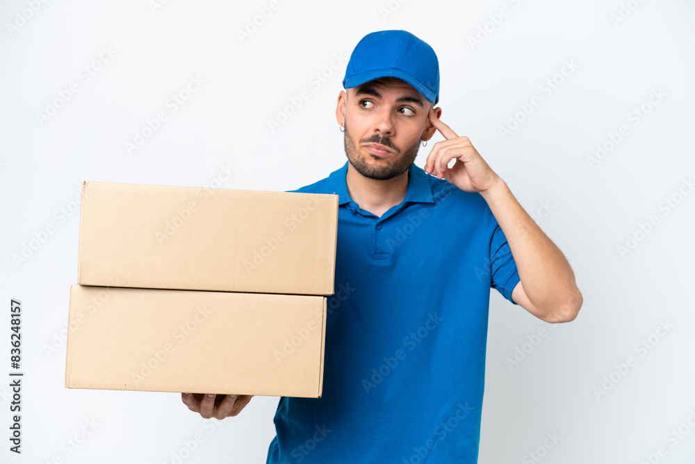Delivery caucasian man isolated on white background having doubts and thinking Delivery caucasian man isolated on white background having doubts and thinking