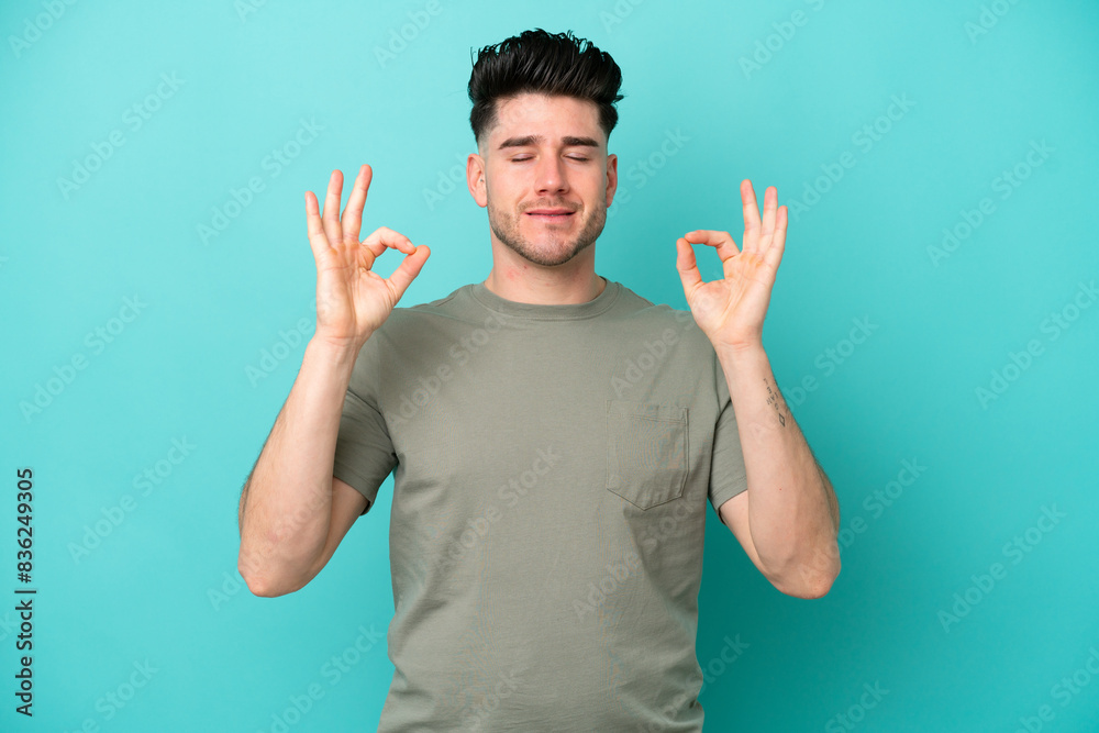 Young caucasian man isolated on blue background in zen pose Young caucasian man isolated on blue background in zen pose