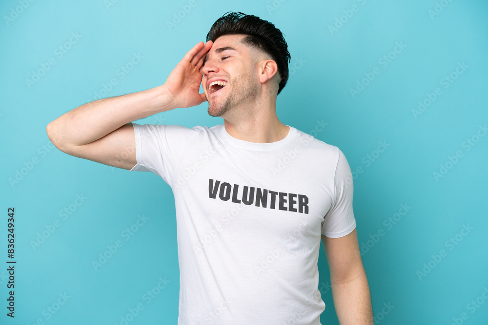 Young volunteer caucasian man isolated on blue background smiling a lot Young volunteer caucasian man isolated on blue background smiling a lot