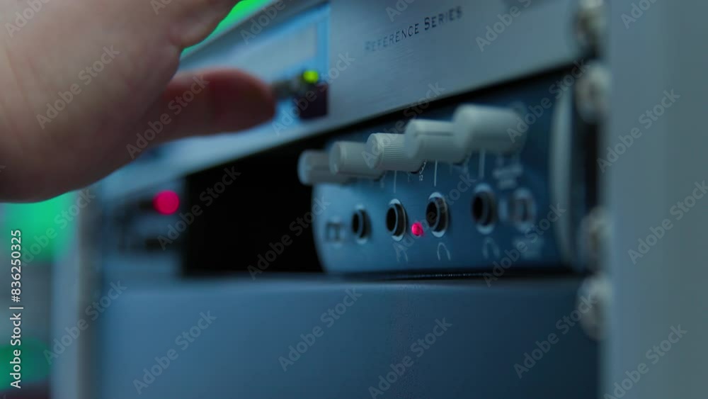 A white and blue electronic device with a red light on it controlled by engineer. A white and blue electronic device with a red light on it controlled by engineer.