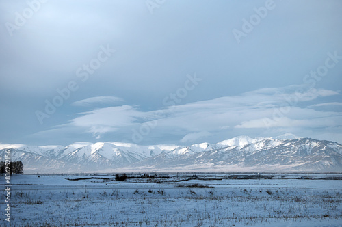 Cold snowy mountain landscape at sunset.