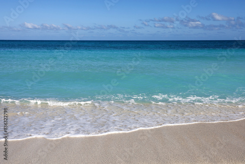 Empty sea beach with white sand  view to azure waves and blue sky with cloud. Caribbean coast  background for holidays on a paradise nature