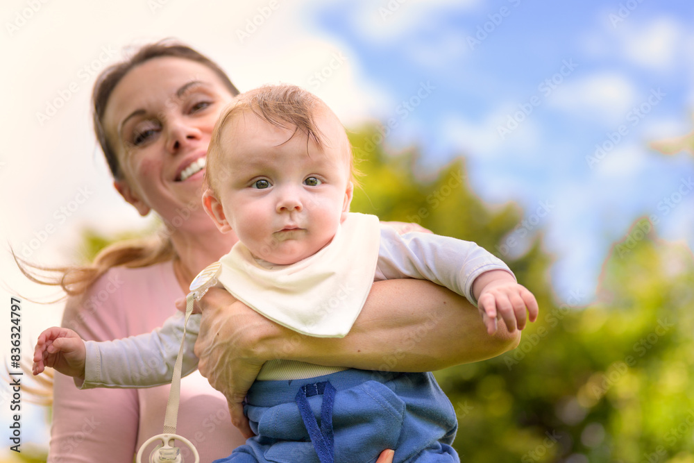 Fototapeta premium Happy Mother Holding Baby Against Green Background