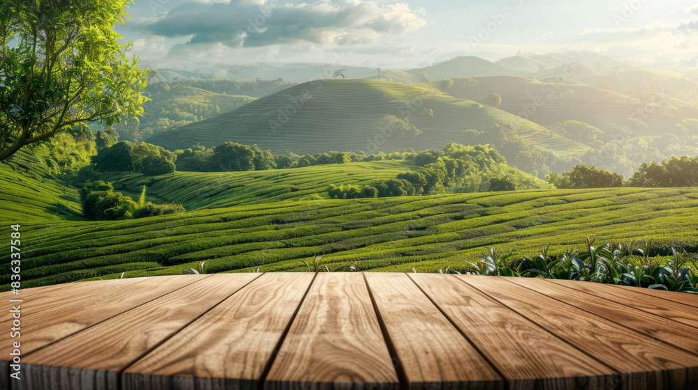 Circle wooden table top with blurred tea plantation landscape against blue sky and blurred green leaf frame Product display concept natural background Circle wooden table top with blurred tea plantation landscape against blue sky and blurred green leaf frame Product display concept natural background