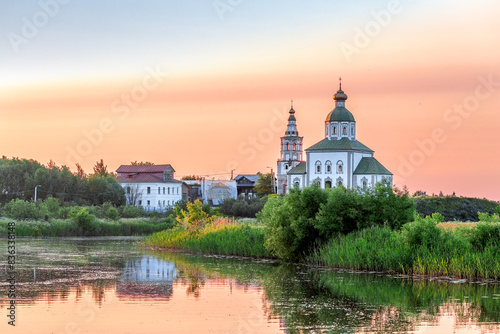 SUZDAL, RUSSIA - Beautiful landscape of Suzdal overlooking the Kamenka River and the ancient Russian Church of Elijah the Prophet (Ilyinsky Church)At sunset