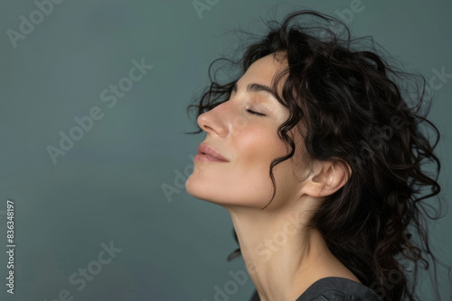 A close up of a woman's face with her eyes closed looking to a side