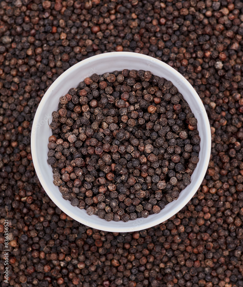 top view background of black peppers (Piper nigrum). Native to Malabar coast of India, it is widely used in culinary as spice and seasoning around the world. top view background of black peppers (Piper nigrum). Native to Malabar coast of India, it is widely used in culinary as spice and seasoning around the world.