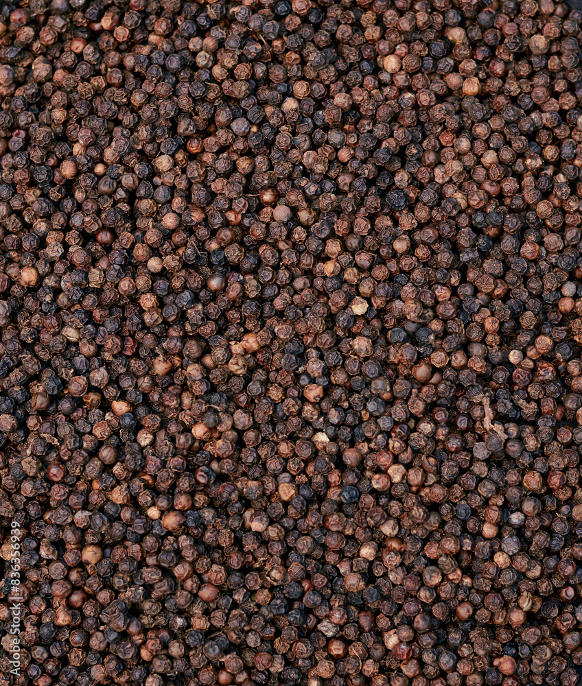 top view background of black peppers (Piper nigrum). Native to Malabar coast of India, it is widely used in culinary as spice and seasoning around the world.