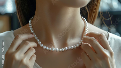 Female customer trying on pearl necklace in shop.