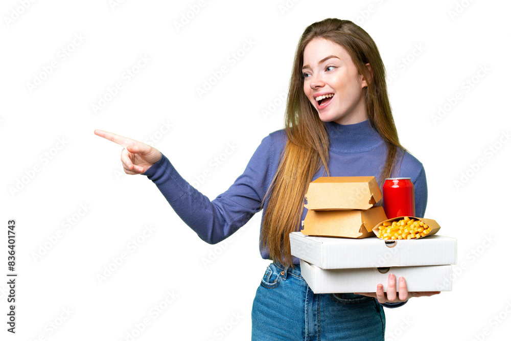 Young pretty woman holding pizzas and burgers over isolated chroma key background pointing finger to the side and presenting a product Young pretty woman holding pizzas and burgers over isolated chroma key background pointing finger to the side and presenting a product