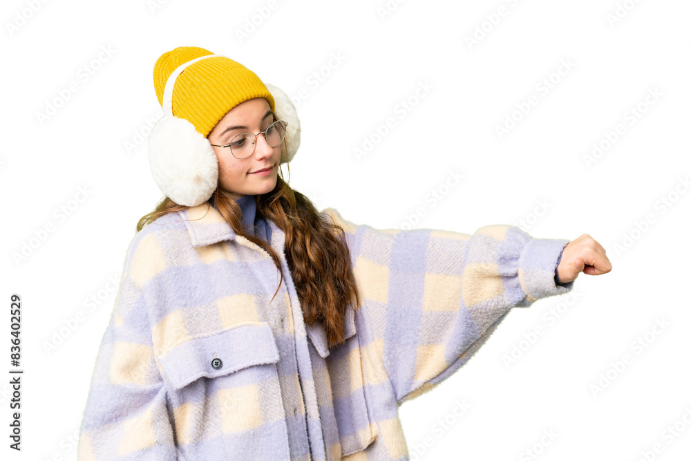Teenager girl wearing winter muffs over isolated chroma key background giving a thumbs up gesture Teenager girl wearing winter muffs over isolated chroma key background giving a thumbs up gesture
