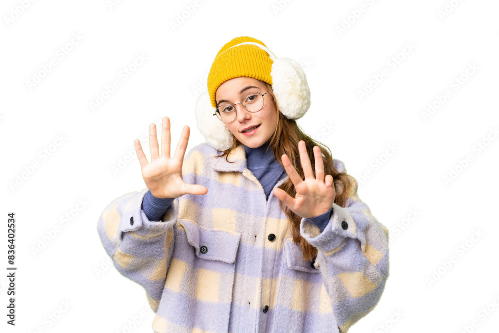 Teenager girl wearing winter muffs over isolated chroma key background counting nine with fingers Teenager girl wearing winter muffs over isolated chroma key background counting nine with fingers