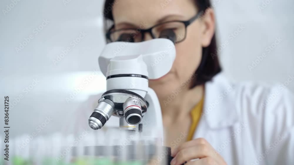 Woman scientist using microscope in laboratory. Microbiology science concept Woman scientist using microscope in laboratory. Microbiology science concept