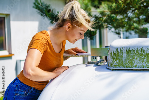 Tableau sur toile Woman checking level of propane gas in tank