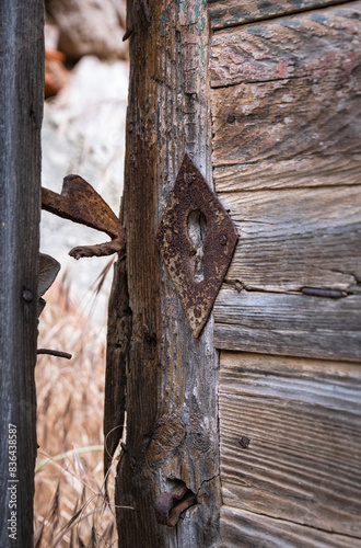 Old and worn wooden door. rusty lock and handle. Antique keyhole.