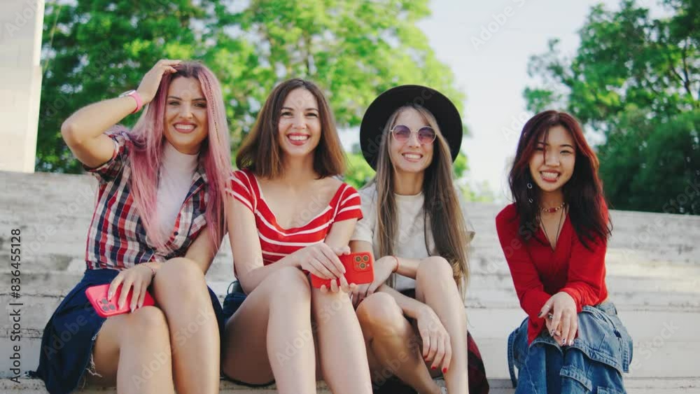 A Group of Multiethnic Young Women. Young beautiful women sit on the steps in a good mood and communicate with each other. A Group of Multiethnic Young Women. Young beautiful women sit on the steps in a good mood and communicate with each other.