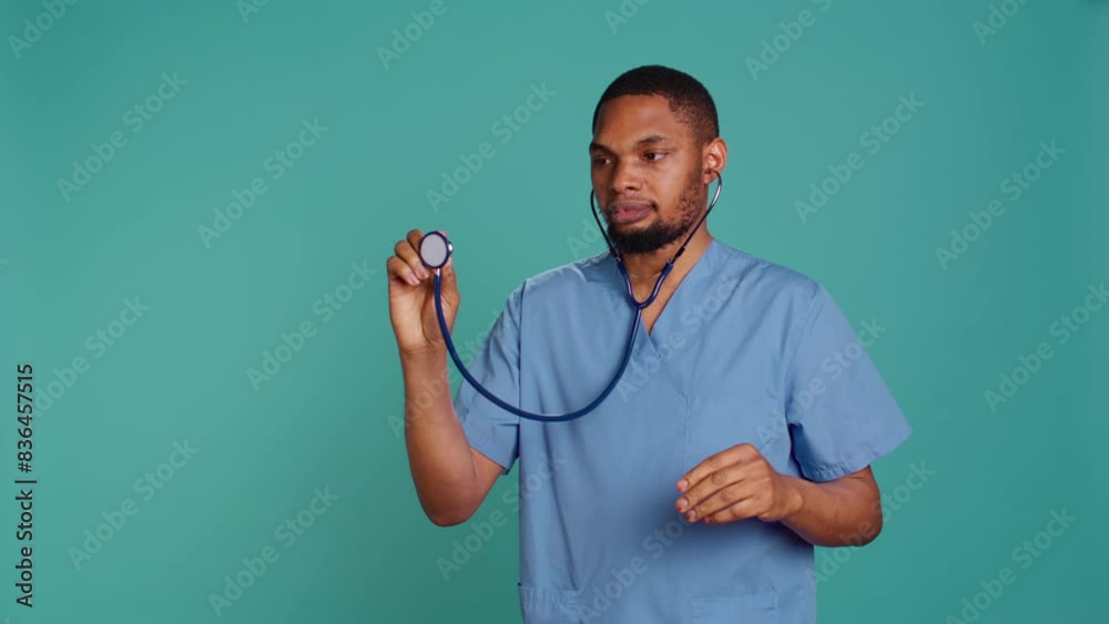 Male nurse using stethoscope on patient during medical exam, hearing heartbeat, isolated over studio background. Healthcare worker using clinic equipment to check for cardiac issues, camera B Male nurse using stethoscope on patient during medical exam, hearing heartbeat, isolated over studio background. Healthcare worker using clinic equipment to check for cardiac issues, camera B